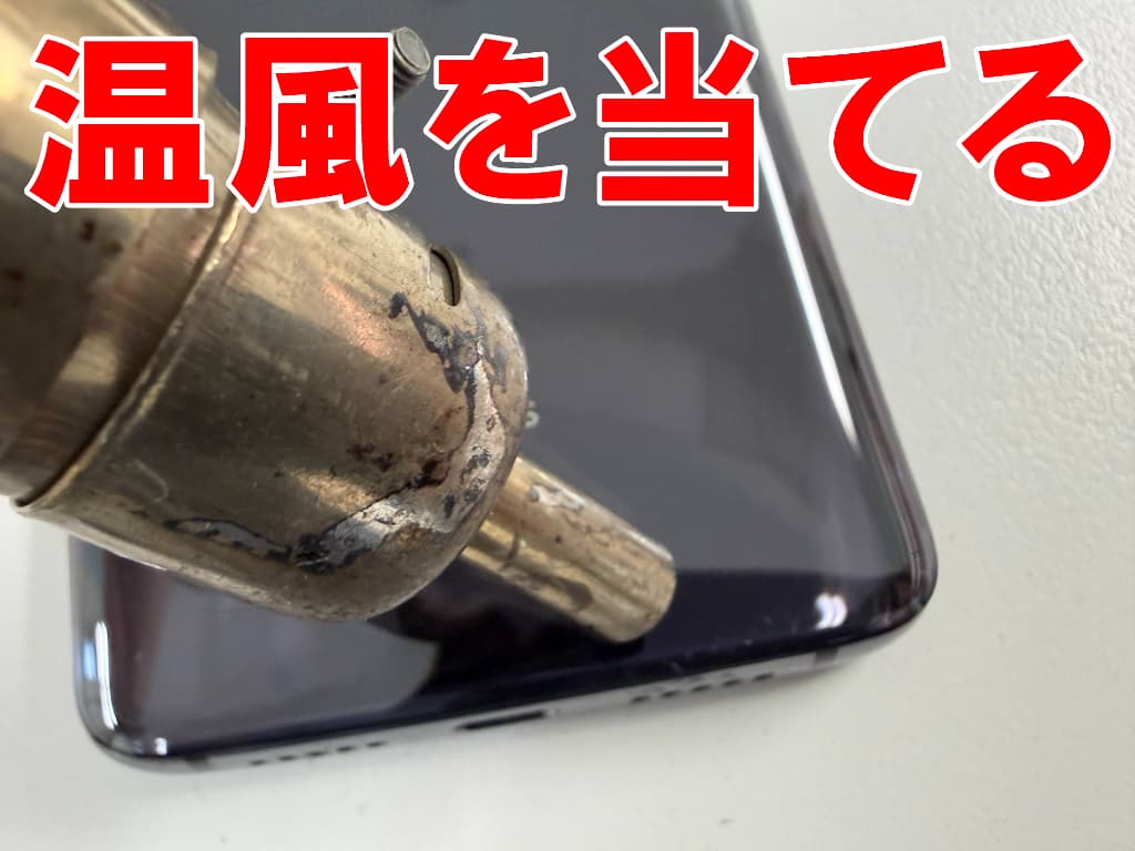 バックパネルに温風を当てている電池交換中のOnePlus7
