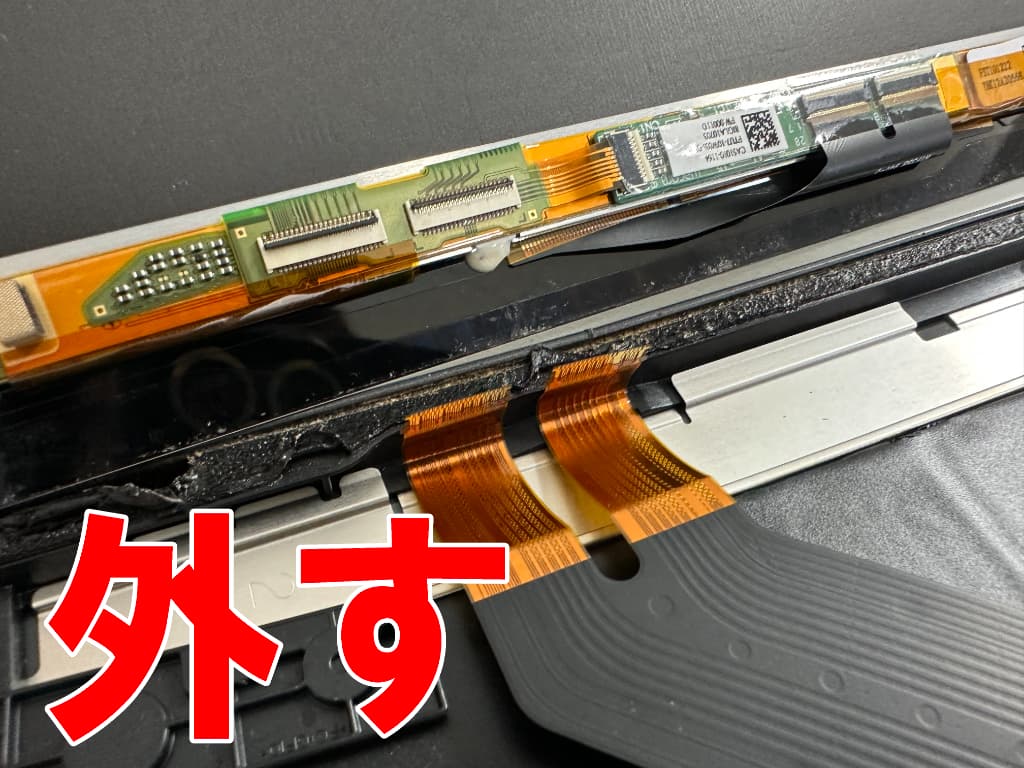 液晶画面に接続されたケーブルを引き抜いた画面交換中のF-02K