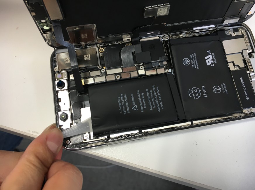 バッテリー固定シール本体上部を引っ張っているiPhoneX