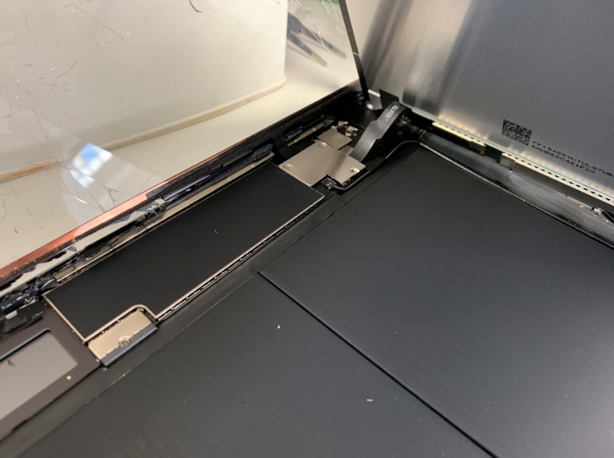 液晶画面コネクタを固定しているプレートが見えているiPad7(2019)
