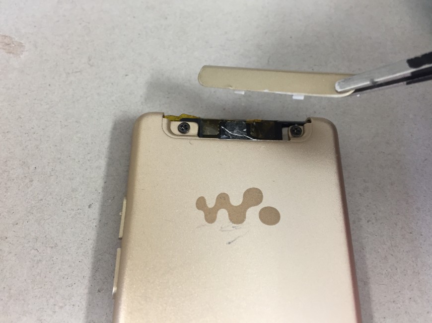 バッテリー交換するために背面の本体上部のプラスチックパーツを剥がしているウォークマン NW-S774