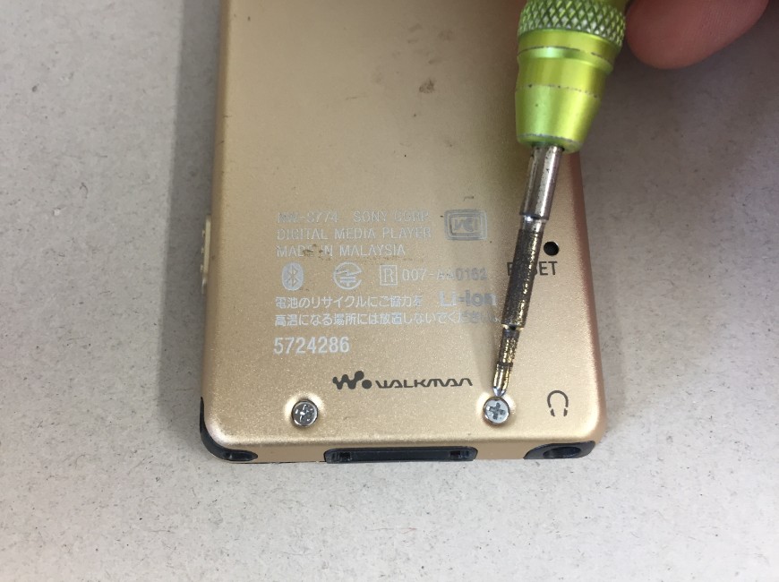 バッテリーを交換するために本体裏のネジを外しているウォークマン NW-S774