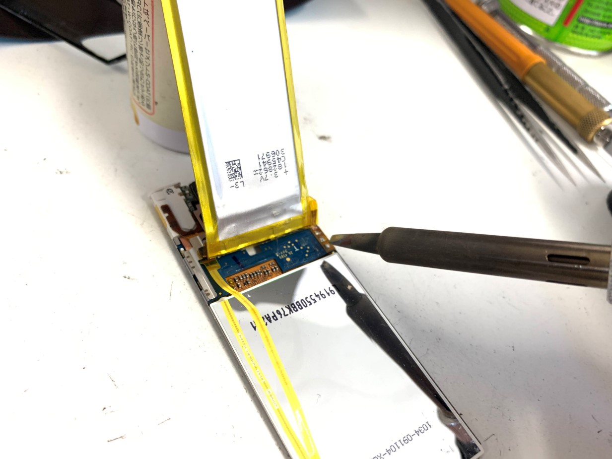 はんだ作業で本体からバッテリーを取り出しているiPod nano 第5世代