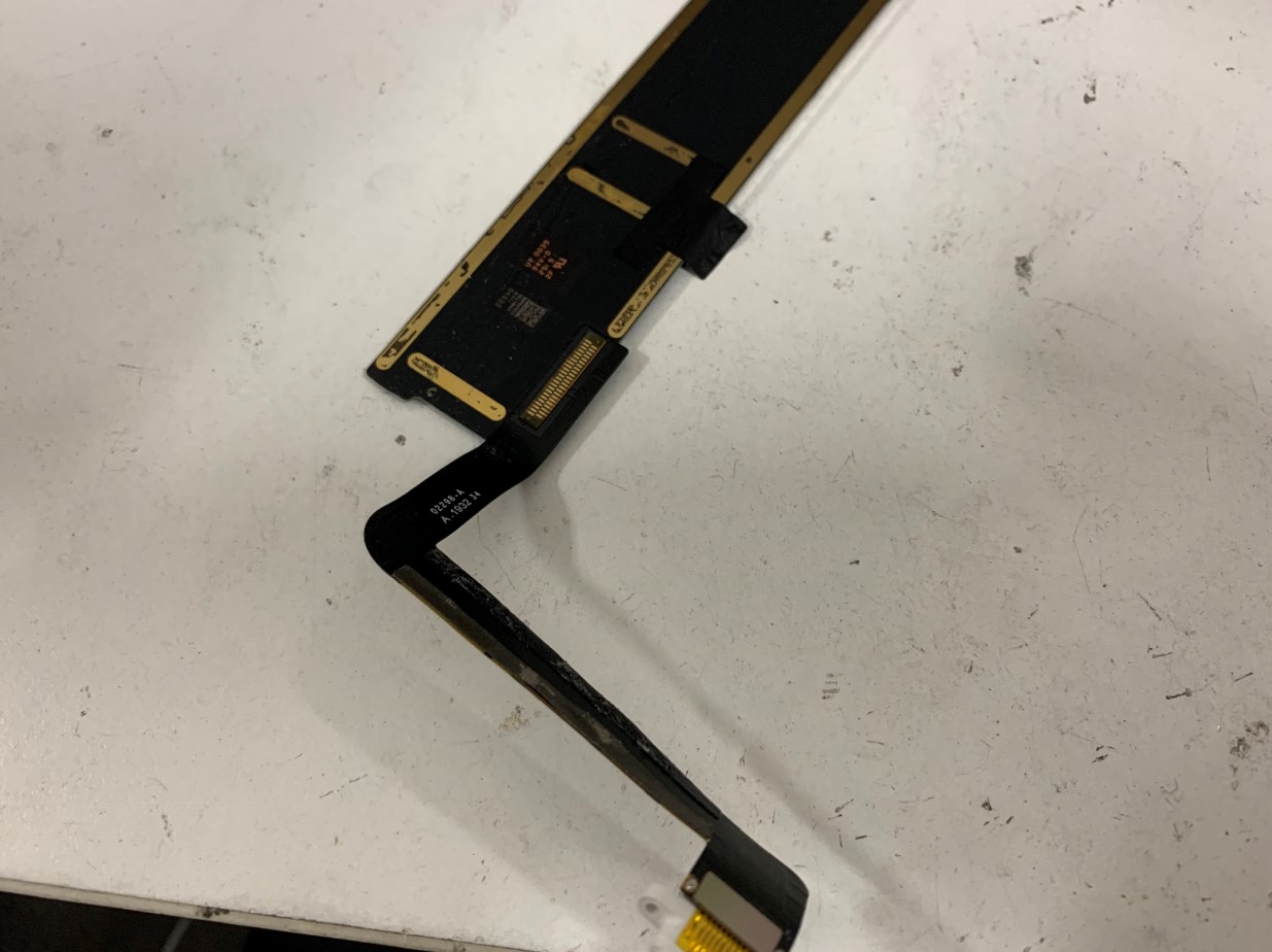 基板からドックコネクターを剥がそうとしているiPad第7世代