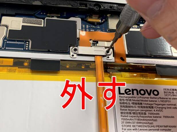 Lenovo IdeaPad Dust Chromebookのバッテリーコネクタを留めた銀板のネジを外そうとしている