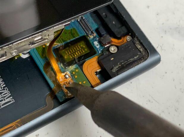 バッテリーの接点にはんだ小手を当てているiPod nano7