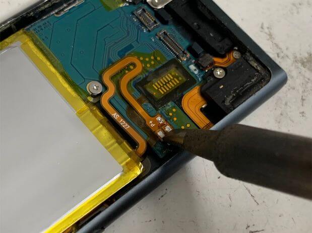 バッテリーコネクタをはんだで基板に固定しているiPod nano7