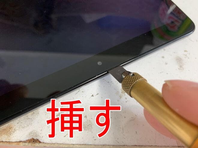 画面と本体フレームの間にクラフトナイフを挿しているGalaxy Tab A 10.1(2019)(SM-T510)