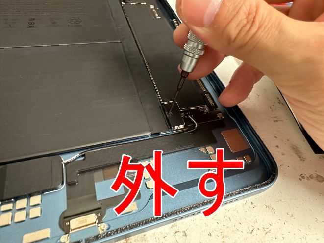 バッテリーコネクタを固定したネジを外しているiPad Air 第5世代