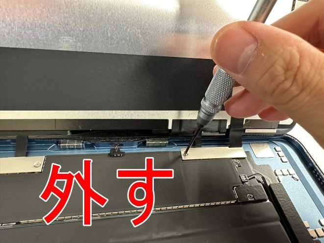 画面パーツコネクタを固定した銀板のネジを外しているiPad Air 第5世代