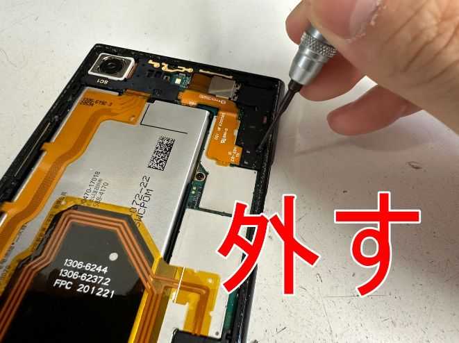 バッテリーコネクタを固定しているプラスチックパーツのネジを外しているXperia XZ Premium
