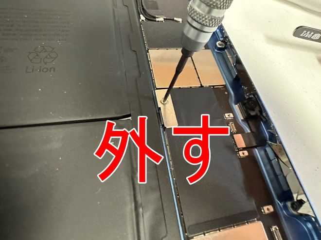 キーボードの接点のコネクタをネジ留めしたネジを外しているiPad 第10世代