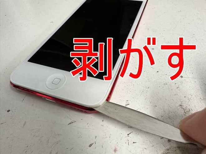 画面左下の粘着を剥がしているiPod Touch 第7世代