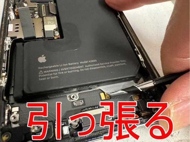 バッテリー固定シールを引っ張ている充電口交換修理前のiPhone14 Pro