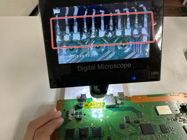 電子顕微鏡を使いながらHDMI端子と基板をはんだ付けしているPS4