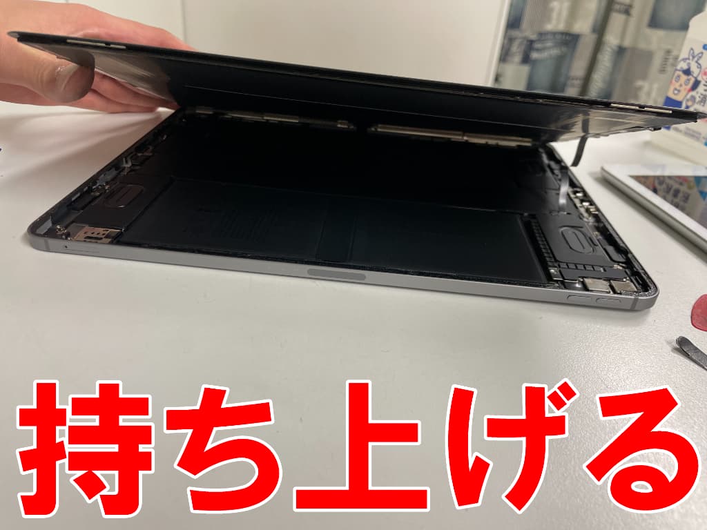 画面パーツを持ち上げている電池パック交換修理中のiPadPro12.9第6世代