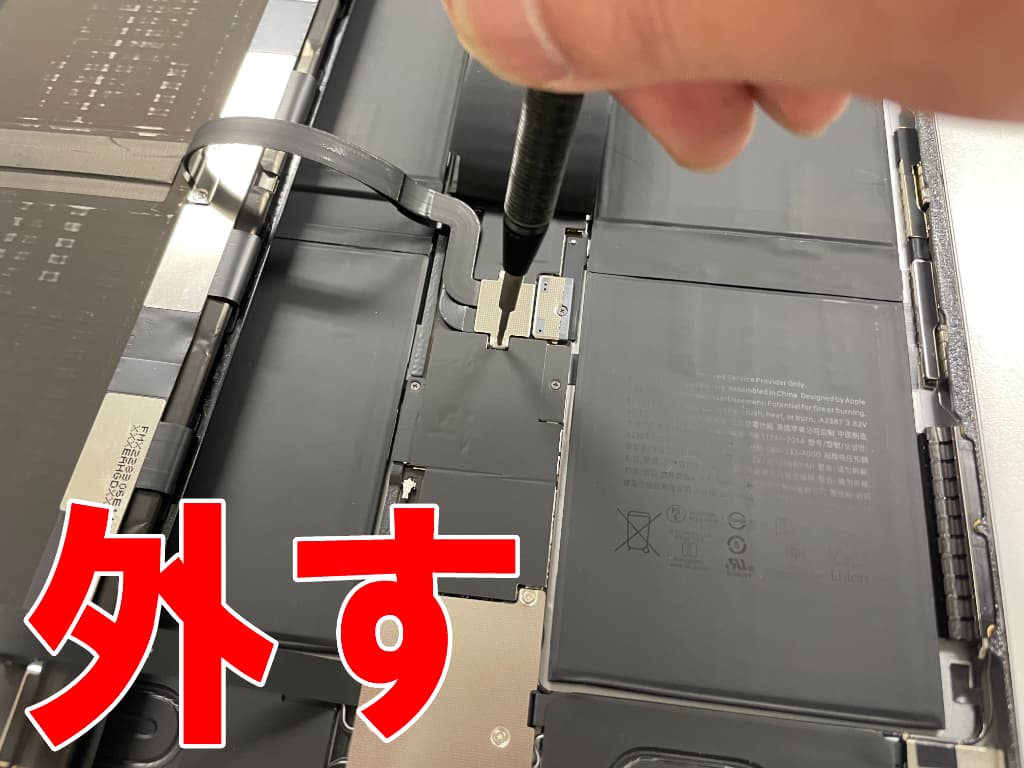 基盤上のプレートのネジを外している電池パック交換修理中のiPadPro12.9第6世代