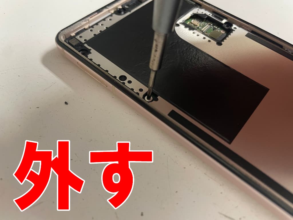 本体内部を覆った大きな銀板のネジを外しているタイプC USB端子交換修理中のAQUOSsense5G