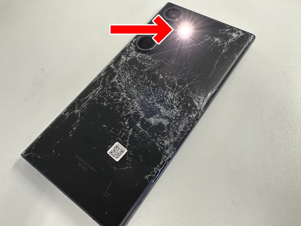 フラッシュが光ったままになっている画面と背面パネルが割れたGalaxy S23Ultra