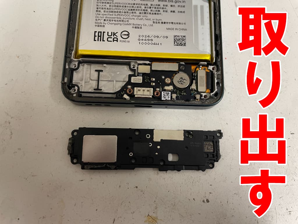 本体下部を覆ったラウドスピーカーを取り出した有機ELディスプレイ修理中のReno11A