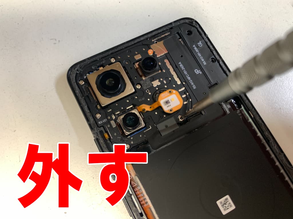 基板を覆ったプラスチックパーツのネジを外している画面修理中の14T Pro