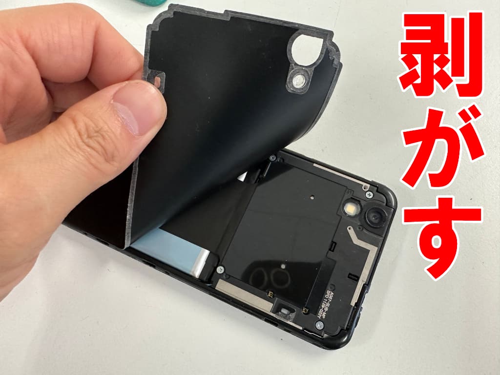 本体内部を覆ったシートを剥がしているリチウムイオンバッテリー交換中のAndroid One S3