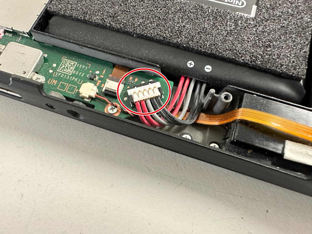 基板にバッテリーコネクタが接続されているイヤホンジャック交換中の Switch(有機ELモデル)