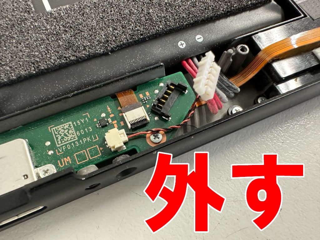 基板からバッテリーコネクタを外したヘッドホンジャック交換中の Switch(有機ELモデル)