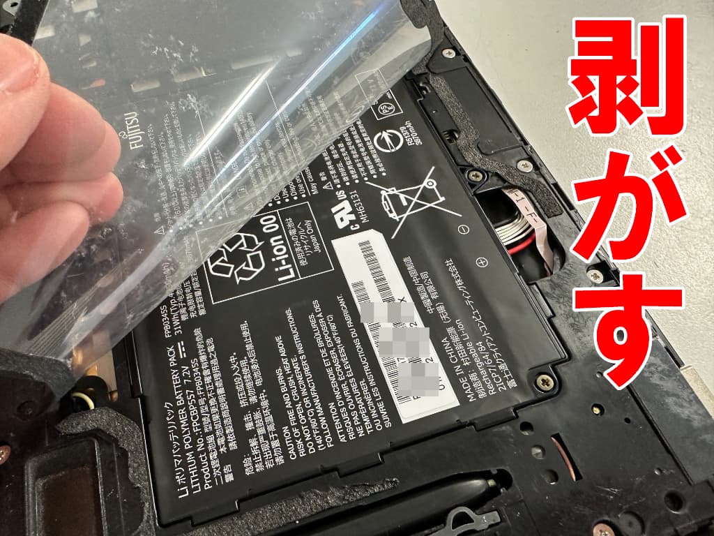 電池パックを覆ったフィルムを更に剥がしているARROWS Tab Q509