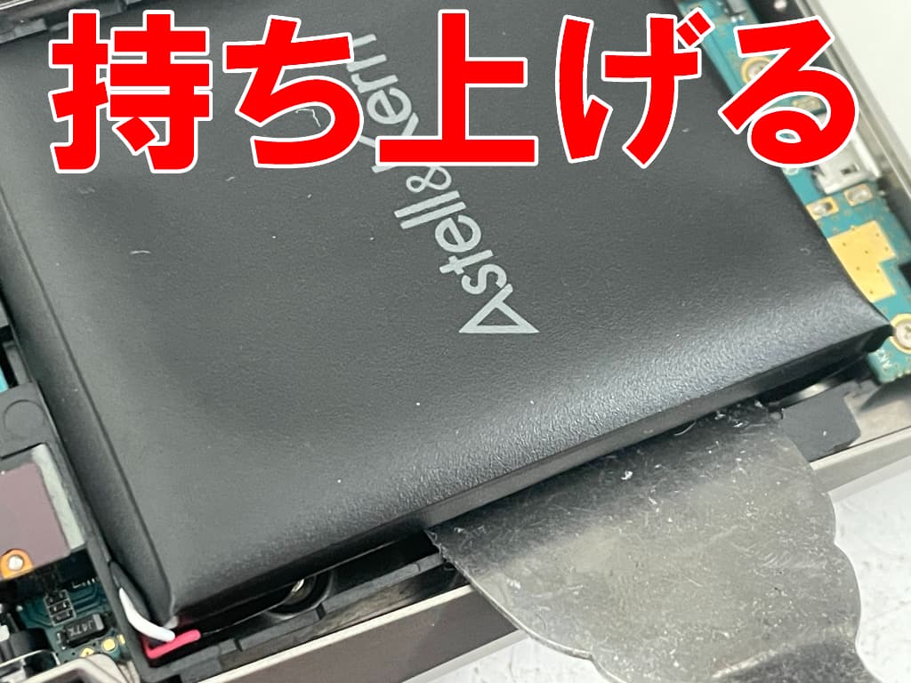 劣化したバッテリーを本体フレームから剥がしているAK240