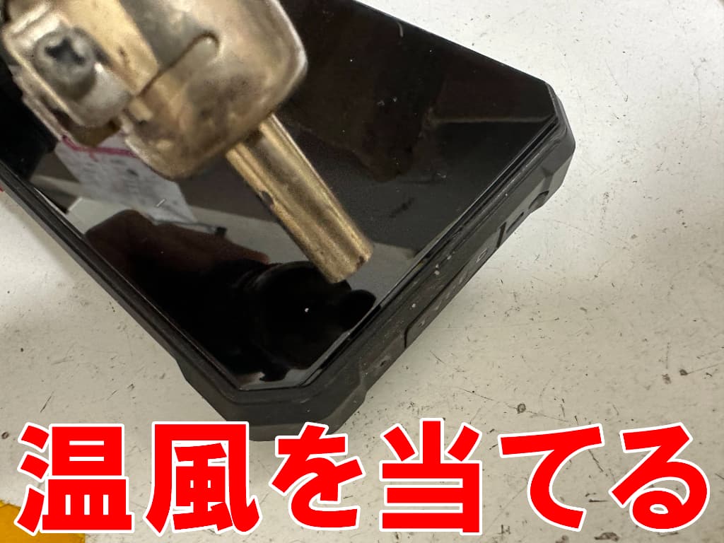 画面に温風を当てて分解しているドックコネクター交換修理中のFOSSiBOT F109