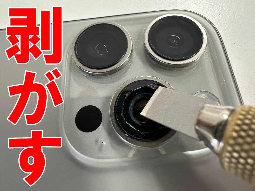 割れたメインカメラレンズを除去しているiPhone16Pro