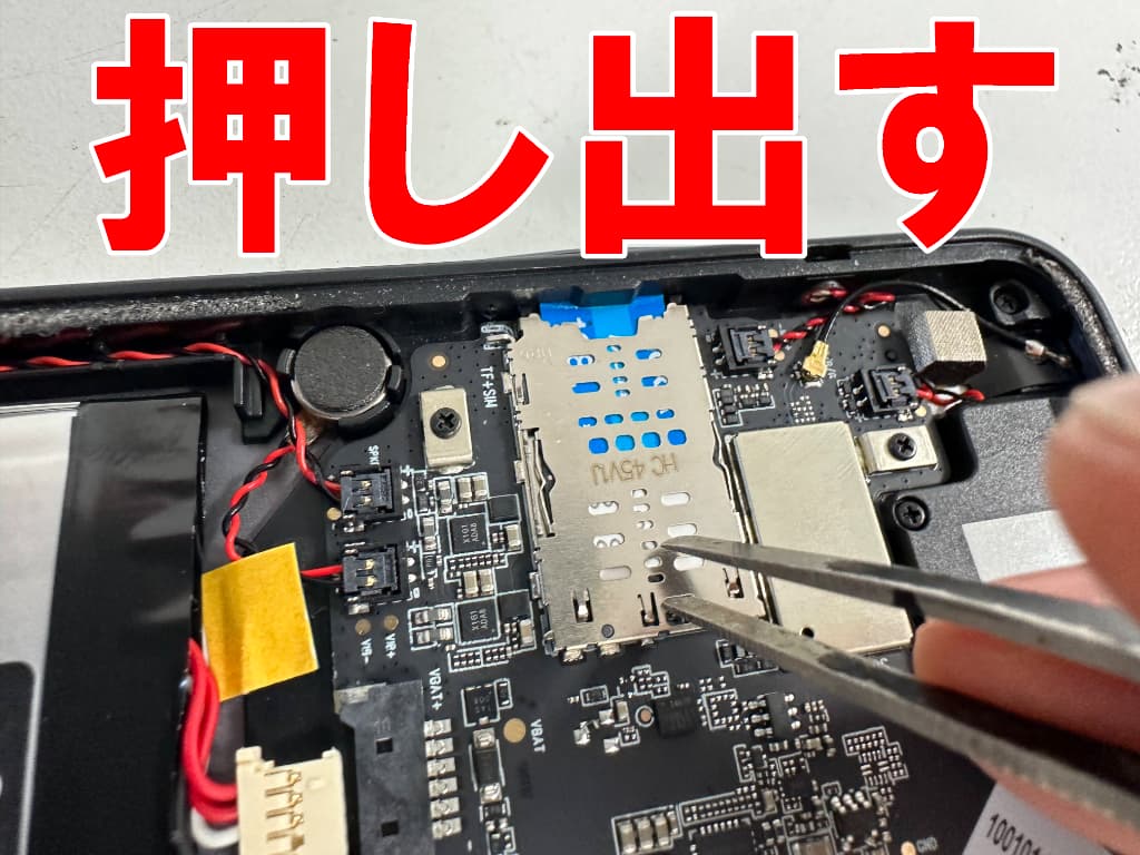 詰まったSIMトレイを本体フレームから押し出しているiPlay 60 mini Pro