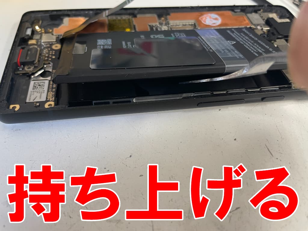 劣化したバッテリーを本体フレームから持ち上げているPixel6a