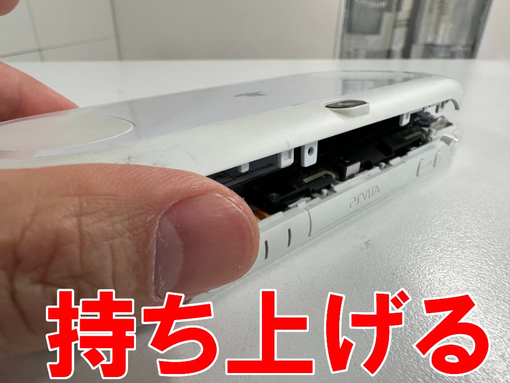 背面パネルを持ち上げているスティック交換前のPSVita-2000