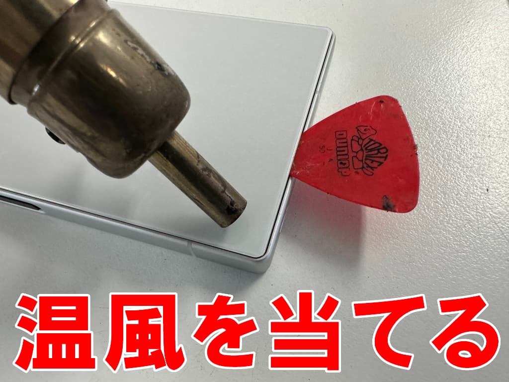 背面パネルに温風を当てて粘着を弱めているメインカメラレンズ交換中のAQUOS R9