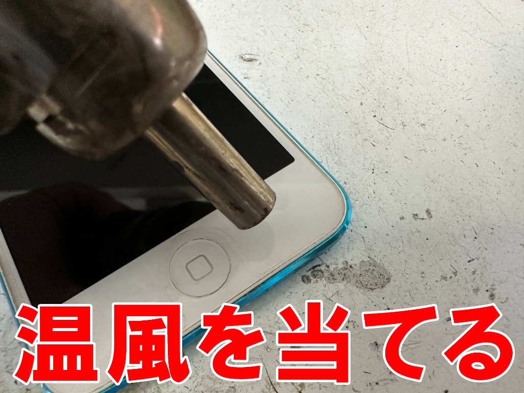 画面の下部に温風を当てている電池交換修理中のiPod touch5