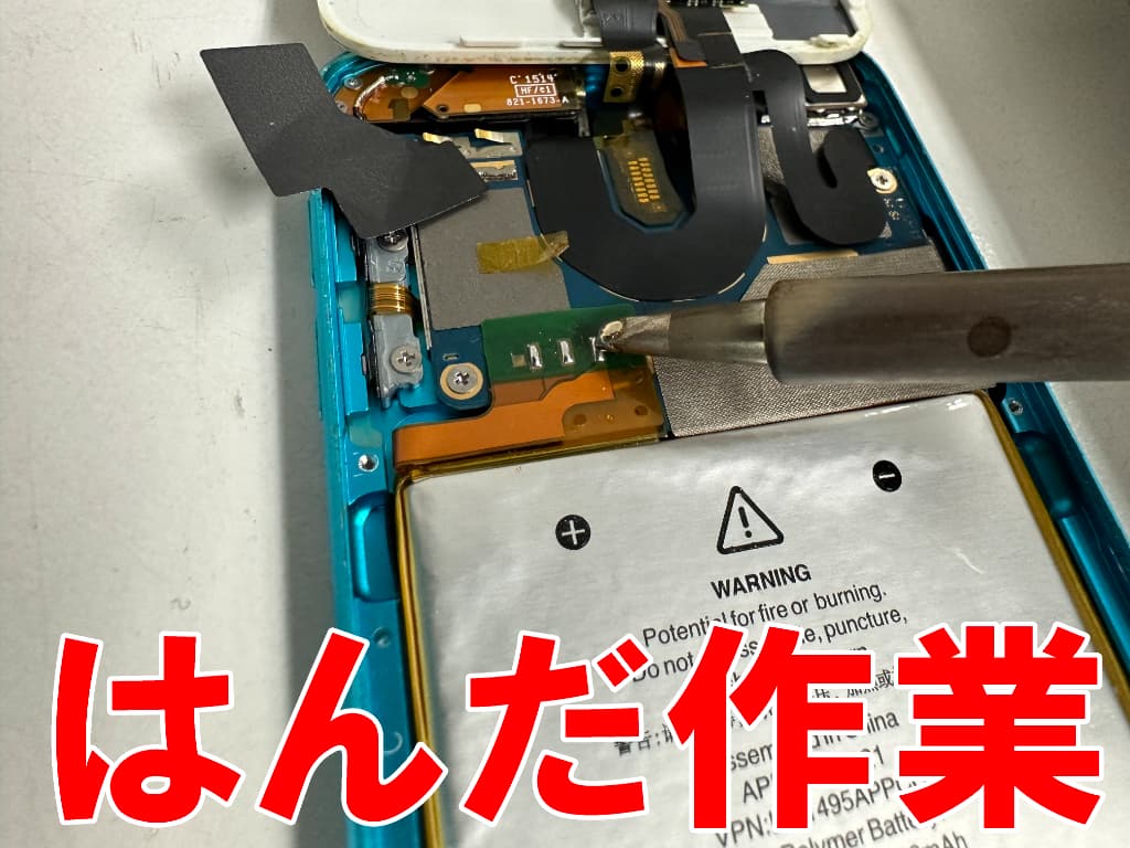 はんだ小手を使ってバッテリーの接点を剥がしているiPod touch 第5世代