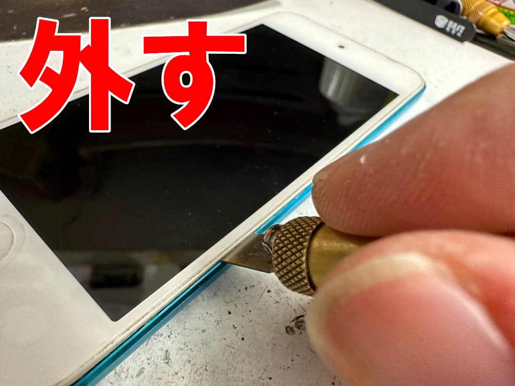 側面のツメを外しているバッテリー交換修理中のiPodTouch第5世代