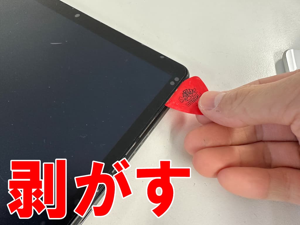 ガラスの粘着を剥がしている充電器差し込み口修理中のTM153M6