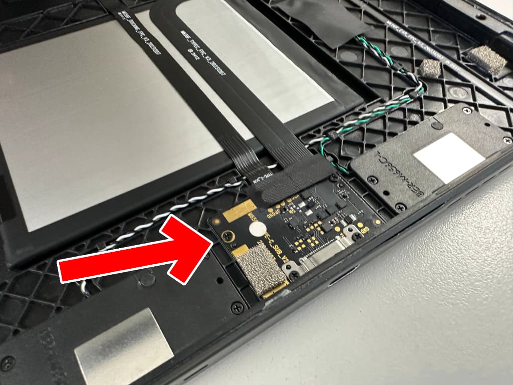 充電口基板からケーブルを引き抜こうとしているドックコネクター交換修理中のアイリスオーヤマタブレットTM153M6