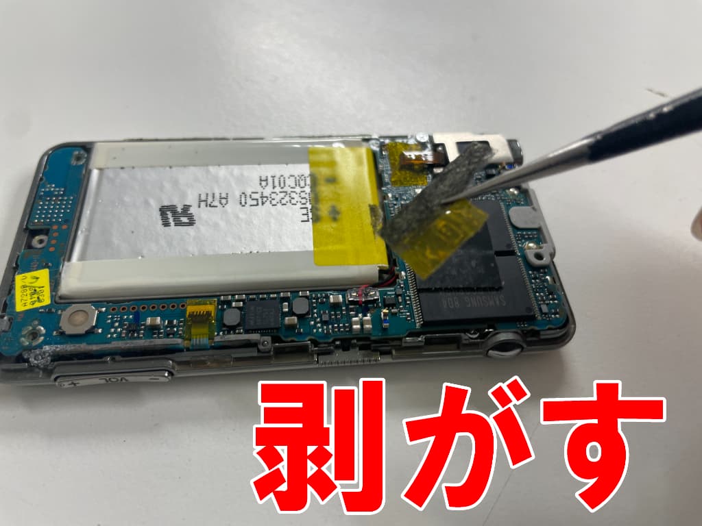バッテリー上の絶縁シールを剥がしているバッテリー交換中のNWZ-A728