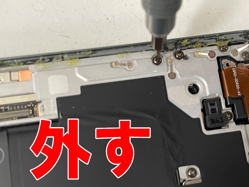 本体内部の銀板を固定したトルクスネジを外しているバッテリー交換修理中のPixel8