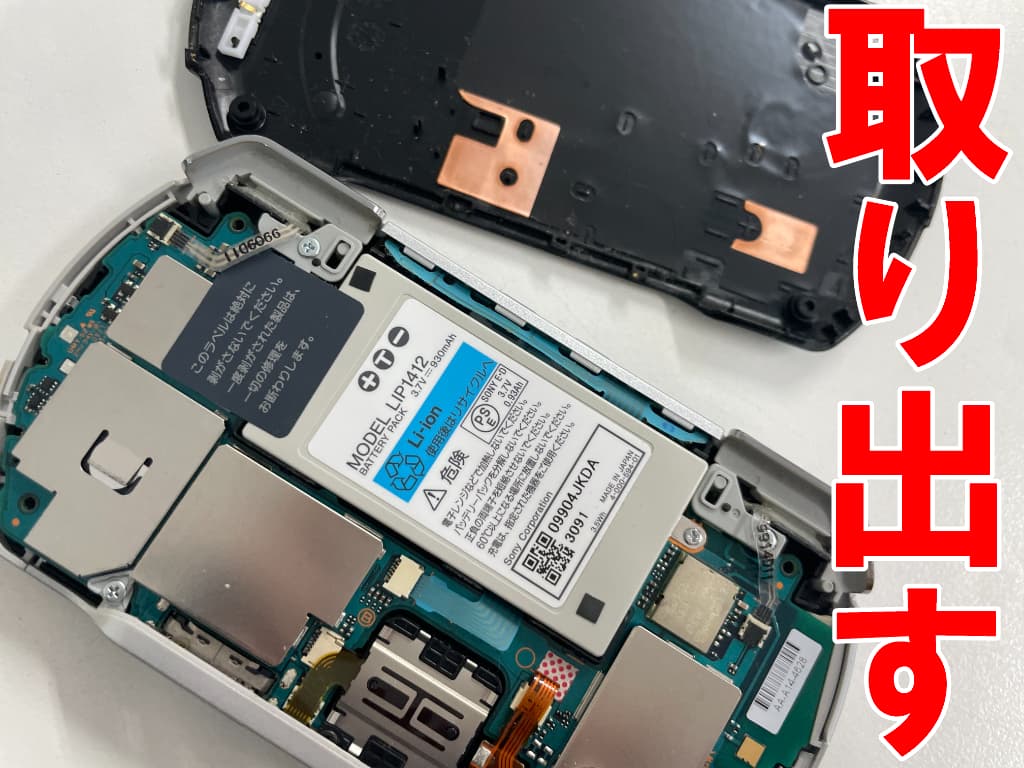 本体フレームからバックパネルを取り出した電池パック交換修理中のPSP go
