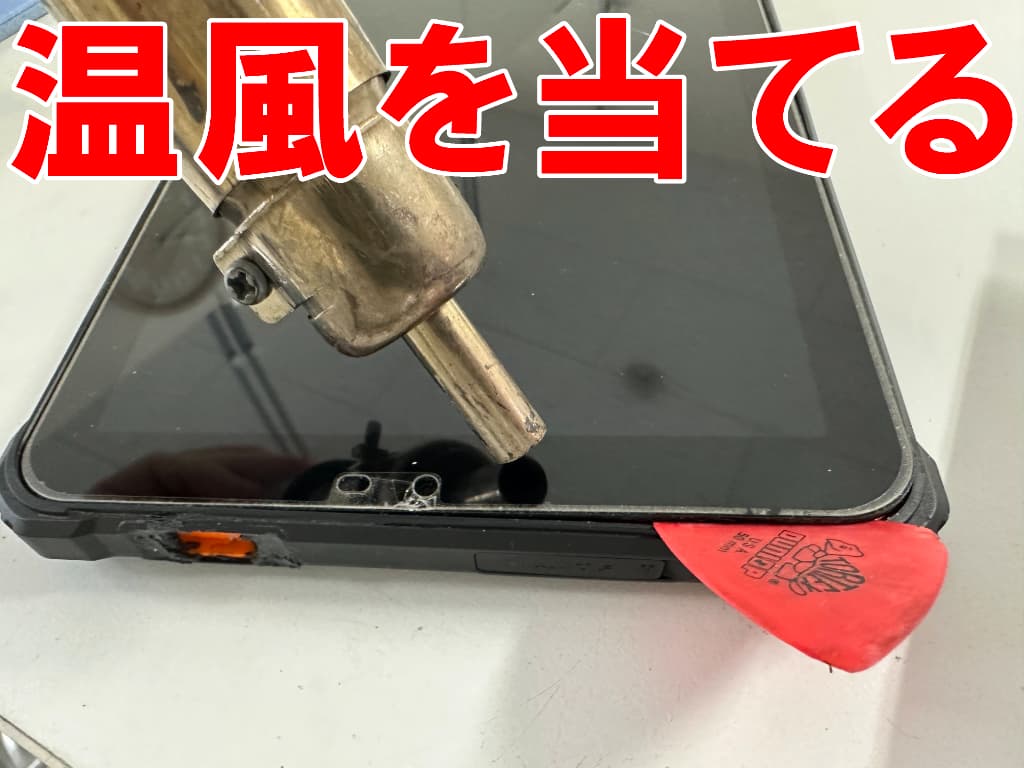 画面に温風を当てているドックコネクター交換修理中のOUKITEL RT3 Pro