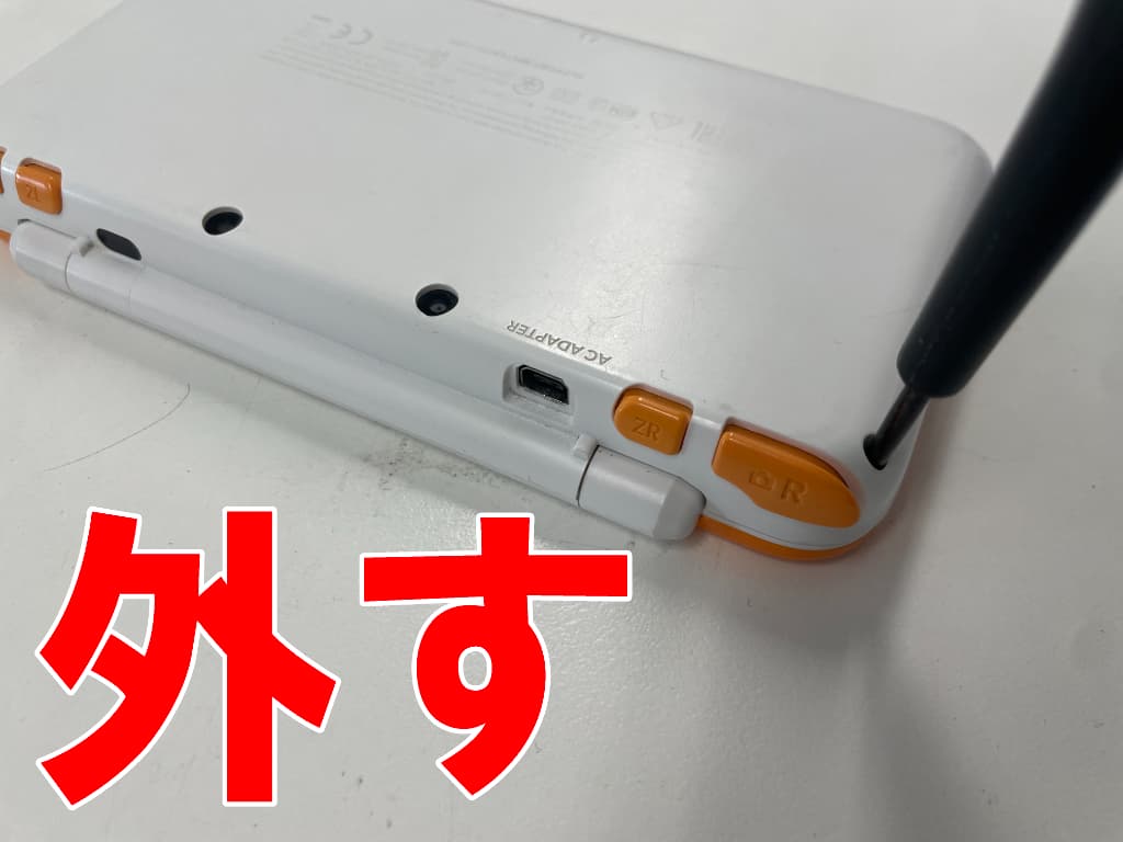 背面パネルを固定したYネジを外しているAボタン修理中のニンテンドー2DSLL