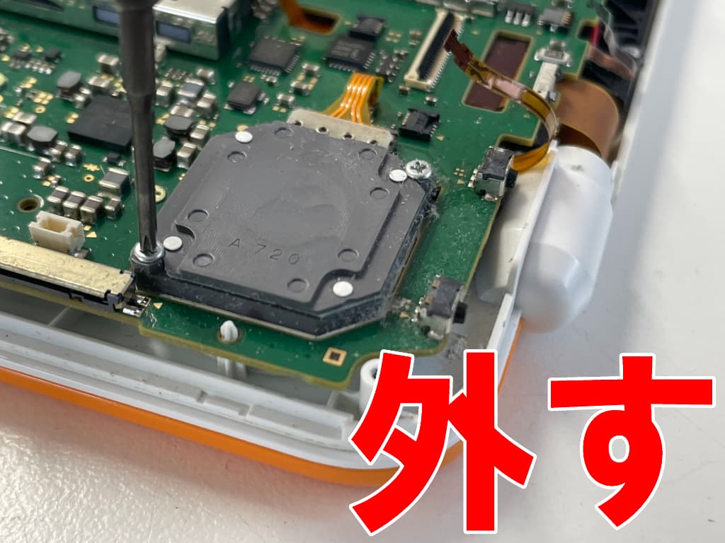 基板上のプラスネジを外しているAボタン修理中の2DSLL