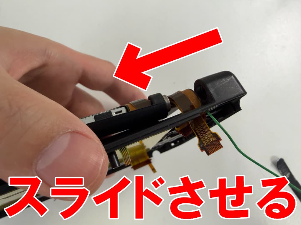 僅かな隙間からケーブル類をスライドさせて本体上下を分離させている上画面修理中の3DSLL