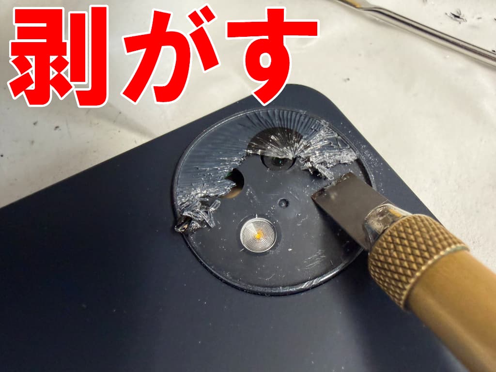 ヒビ割れたカメラレンズを本体フレームから剥がしているAQUOS wish4