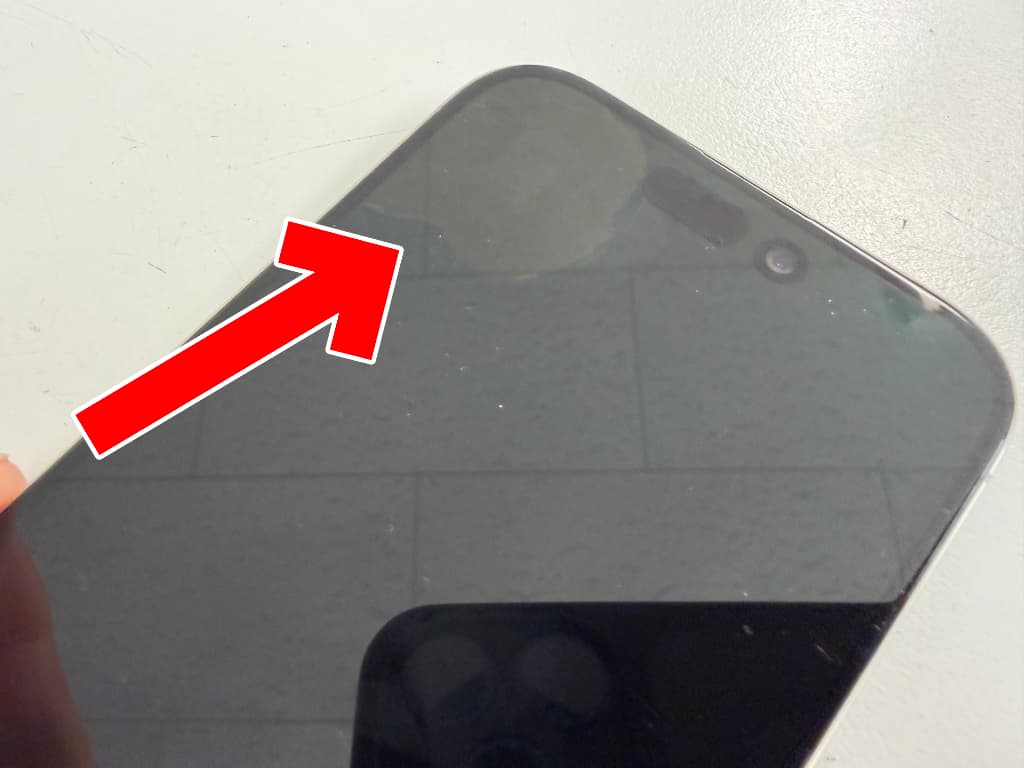 画面上部が液漏れしている修理前のiPhone 15 Pro